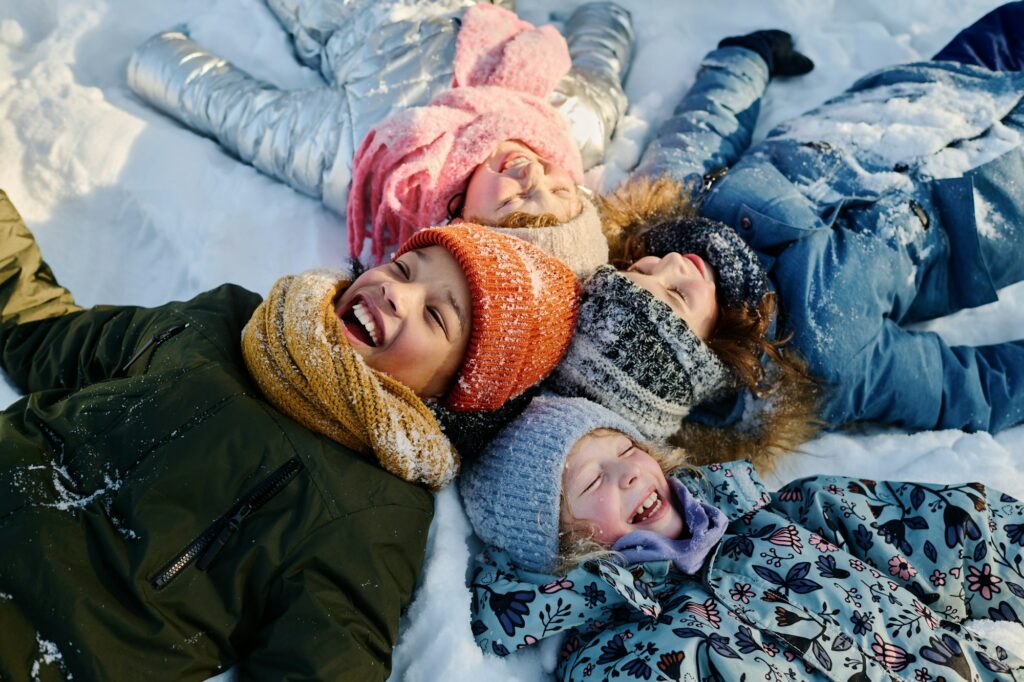 Children lying on snow and laughing