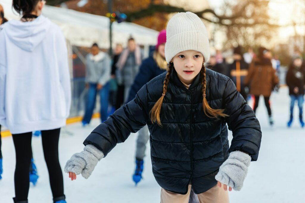 Portrait of little kid girl friend enjoy having fun at outdoor ice skating rink while travel in old